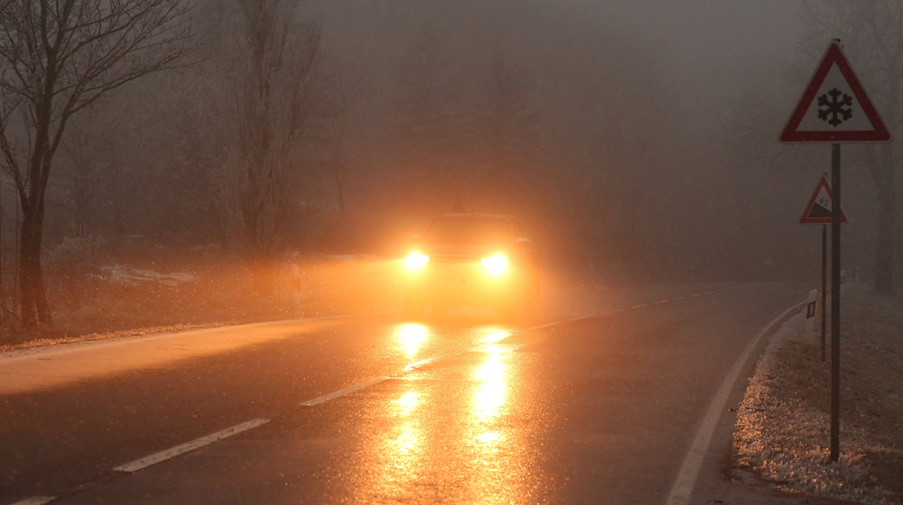 Ein Auto fährt bei Glatteis und Nebel über eine Straße. / Foto: Matthias Bein/dpa-Zentralbild/dpa/Symbolbild