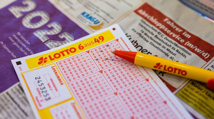 Ein Lottoschein und ein Kugelschreiber liegen in einer Annahmestelle auf dem Tresen. / Foto: Philipp von Ditfurth/dpa/Illustration