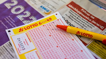 Ein Lottoschein und ein Kugelschreiber liegen in einer Annahmestelle auf dem Tresen. / Foto: Philipp von Ditfurth/dpa/Illustration