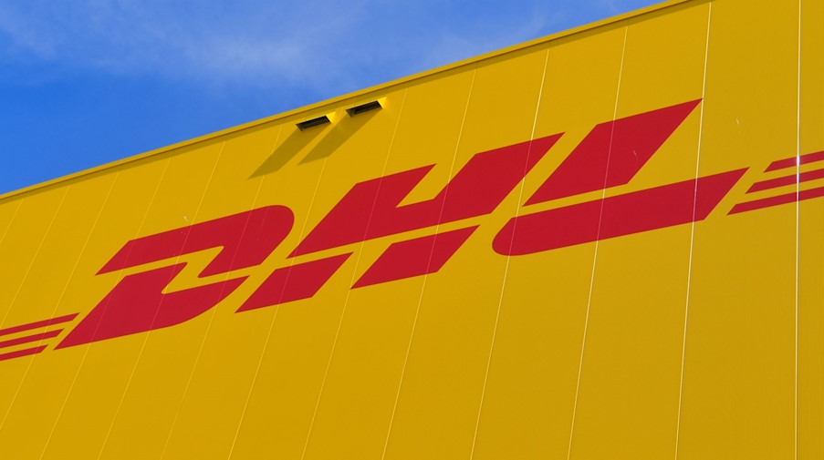 Das Logo des Paketdienstes DHL der Deutschen Post auf der Fassade eines Paketzentrums. / Foto: Patrick Pleul/dpa-Zentralbild/dpa/Archivbild