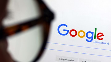 Die Seite der Suchmaschine von Google ist hinter einer Frau mit Brille zu sehen. / Foto: Karl-Josef Hildenbrand/dpa/Illustration