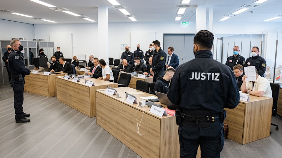 Die Angeklagten sitzen im Oberlandesgericht Dresden neben ihren Anwälten. / Foto: Jens Schlueter/AFP Pool/dpa/Archivbild