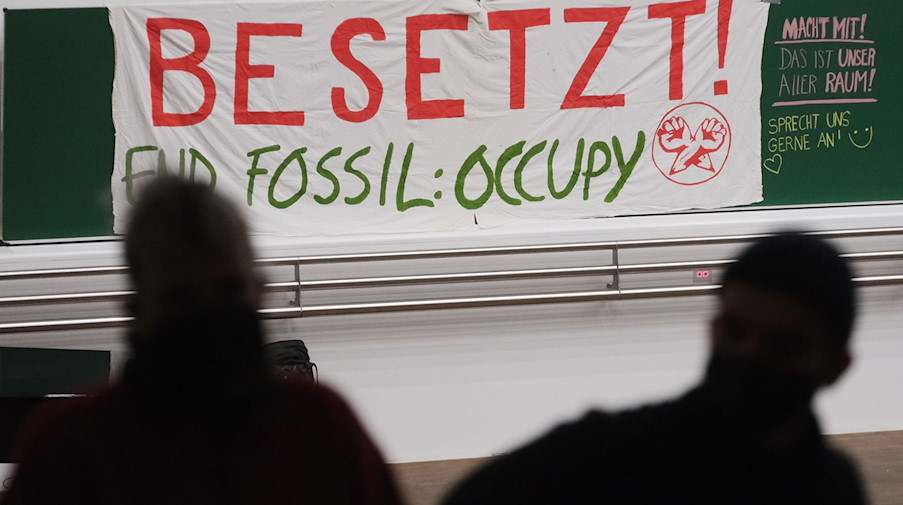 Ein Transparent mit der Aufschrift «Besetzt» hängt im Auditorium Maximum der Universität Leipzig. / Foto: Sebastian Willnow/dpa/