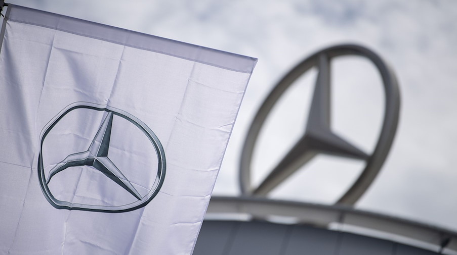 Eine Fahne mit dem Logo der Marke Mercedes-Benz, weht im Wind. / Foto: Sebastian Gollnow/dpa/Archivbild