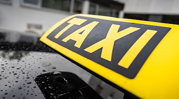 Ein Taxi-Schild ist auf dem Dach eines Fahrzeuges befestigt. / Foto: Frank Rumpenhorst/dpa/Frank Rumpenhorst/dpa/Symbolbild
