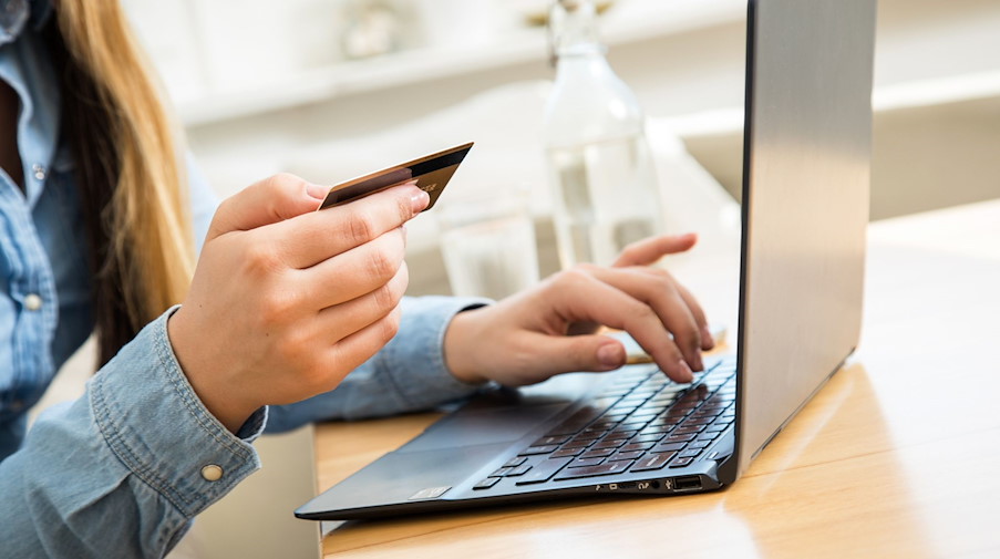 Eine Frau tippt ihre Kreditkarten-Daten in einen Laptop. / Foto: Christin Klose/dpa-tmn/Symbolbildarchiv