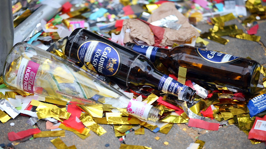 Leere Bierflaschen liegen zwischen Müll und Konfetti auf der Straße. / Foto: Oliver Berg/dpa/Symbolbild