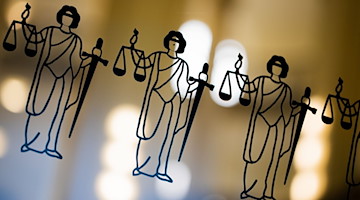 Die Justitia ist an einer Scheibe am Eingang zum Oberlandesgericht zu sehen. / Foto: Rolf Vennenbernd/dpa/Symbolbild