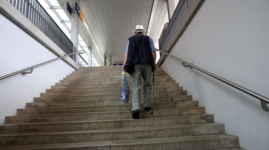 Ein älterer Mann mit Gehstock geht auf einer Treppe in einer Bahnhofsunterführung. / Foto: picture alliance/dpa/Symbolbild