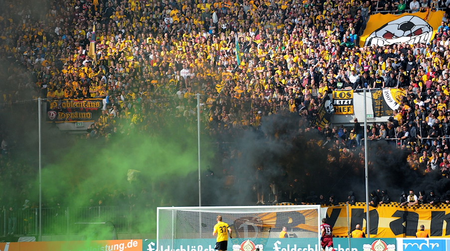 Fans von Dynamo Dresden legen Feuer in ihrem Block. / Foto: Thomas Eisenhuth/dpa/Archivbild