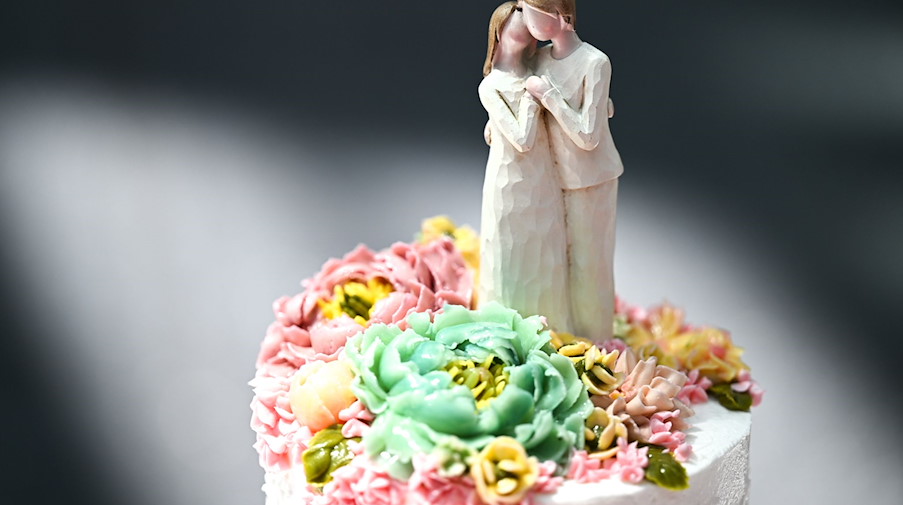 Eine Figur, die einen Mann und eine Frau darstellt, steht auf einer Hochzeitstorte. / Foto: Felix Kästle/dpa/Symbolbild