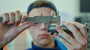 Ein Lehrling zum Mechatroniker prüft mit einem Messschieber ein Werkstück. / Foto: Patrick Pleul/dpa/Symbolbild