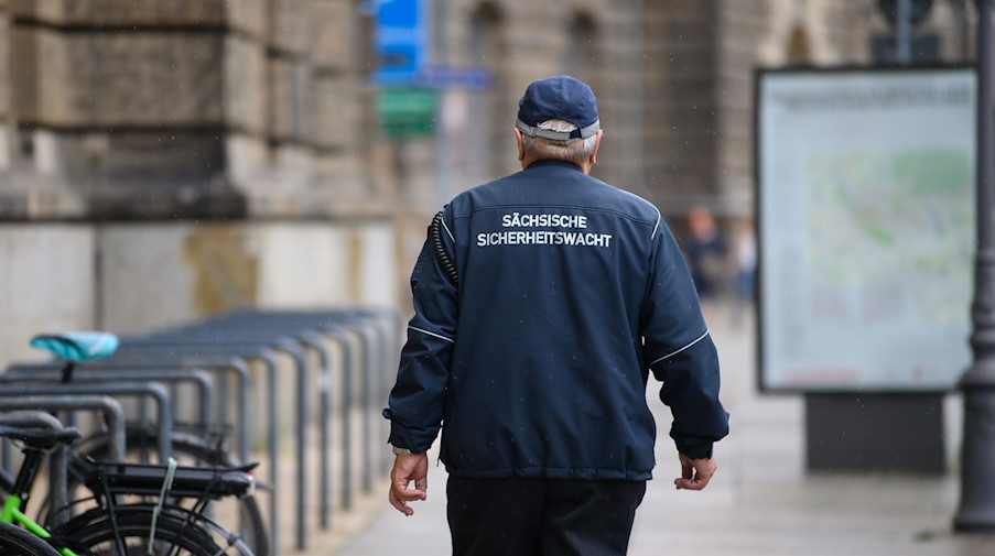 Ein ehrenamtlicher Mitarbeiter der Sächsischen Sicherheitswacht läuft einen Fußweg in der Innenstadt entlang. / Foto: Robert Michael/dpa-Zentralbild/dpa/Archivbild