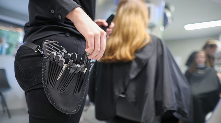 Eine Friseurmeisterin schneidet einer Kundin die Haare. / Foto: Jan Woitas/dpa/Symbolbild