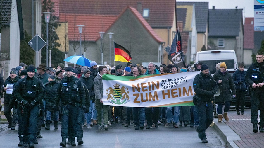 «Nein zum Heim, wir sind nicht das Sozialamt der Welt» steht auf einem Transparent während des Protests in Strelln. / Foto: Bernd März/dpa