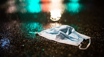 Ein Mund-Nasenschutz liegt im Regen auf der Strasse. / Foto: Christoph Schmidt/dpa/Symbolbild