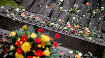 Zahlreiche Rosen liegen auf einer Gedenkstätte. / Foto: Hauke-Christian Dittrich/dpa/Archivbild
