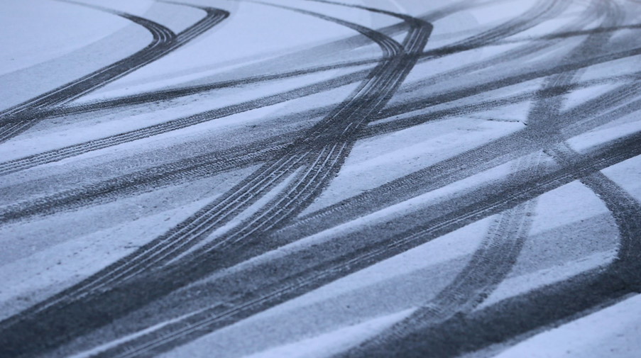 Reifenspuren zeichnen sich auf einer Straße im Schnee ab. / Foto: Karl-Josef Hildenbrand/dpa/Symbolbild