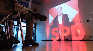 Olaf Scholz (SPD), Bundeskanzler, ist bei einer Videobotschaft auf einer Leinwand zu sehen. / Foto: Sebastian Willnow/dpa