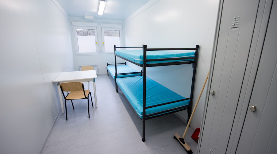 Blick in ein Zimmer mit drei Betten in einer Flüchtlingsunterkunft. / Foto: picture alliance / dpa