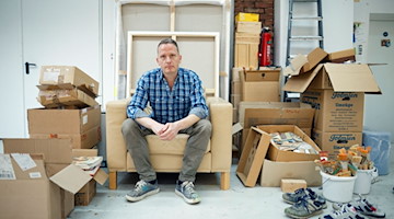 Der Maler Norbert Bisky sitzt in seinem Atelier. / Foto: Carsten Koall/dpa