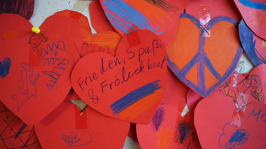 Rote Herzen mit Friedenssymbolen und Wünschen von Schülerinnen und Schülerin sind zu sehen. / Foto: Marcus Brandt/dpa/Archivbild