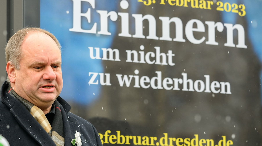 Dirk Hilbert (FDP), Oberbürgermeister der Stadt Dresden, steht während der Präsentation neben dem Plakat zum Aufruf einer Menschenkette am 13. Februar 2023 auf den Neumarkt vor der Frauenkirche. / Foto: Robert Michael/dpa/Archivbild