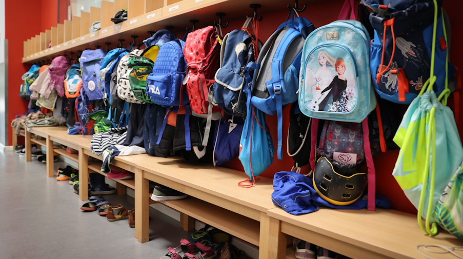 Sporttaschen und Schulranzen hängen an der Garderobe vor einem Klassenzimmer. / Foto: Christian Charisius/dpa/Symbolbild