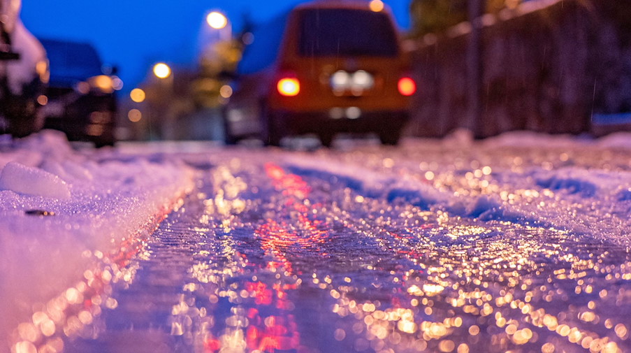 Eine dünne Eisschicht überzieht am frühen Morgen eine Straße. / Foto: Armin Weigel/dpa/Symbolbild