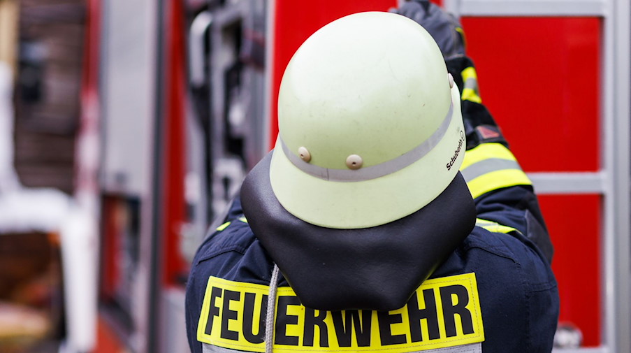 Ein Feuerwehrmann holt während einer Einsatzübung einer Freiwilligen Feuerwehr eine Leiter vom Dach eines Einsatzfahrzeugs. / Foto: Philipp von Ditfurth/dpa/Archivbild