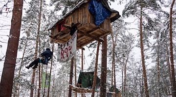 Klimaaktivisten sind in einem von ihnen besetzten Waldstück unterwegs. / Foto: Matthias Rietschel/dpa/Archivbild