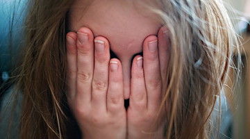 Ein junges Mädchen hält sich die Hände vor ihr Gesicht. / Foto: Nicolas Armer/dpa/Symbolbild