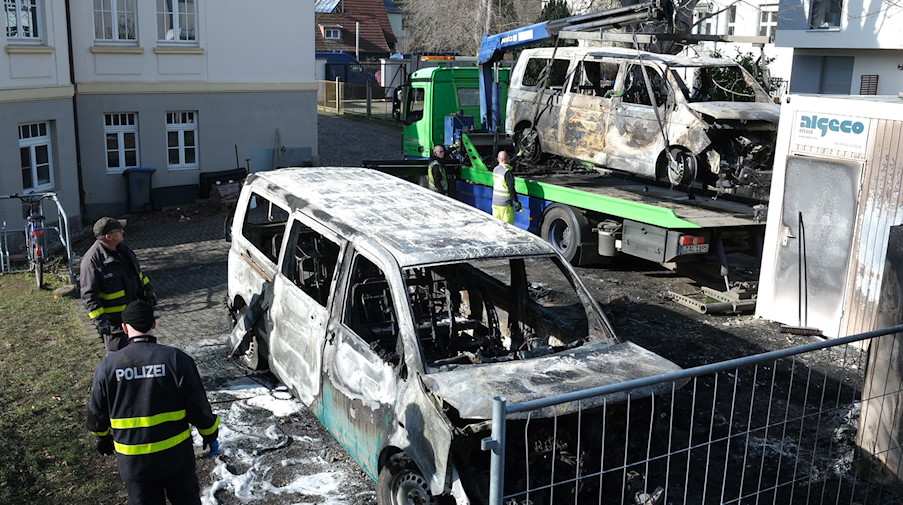 Ausgebrannte Fahrzeuge vom Staatsbetrieb Sachsenforst werden von der Polizei gesichert. / Foto: Sebastian Willnow/dpa