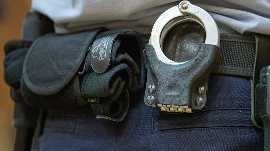 Handschellen stecken in der Gürtelhalterung eines Justizbeamten. / Foto: Friso Gentsch/dpa/Symbolbild