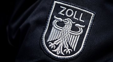 Das Zoll-Abzeichen auf der Uniform eines Beamten. / Foto: Sina Schuldt/dpa/Symbolbild