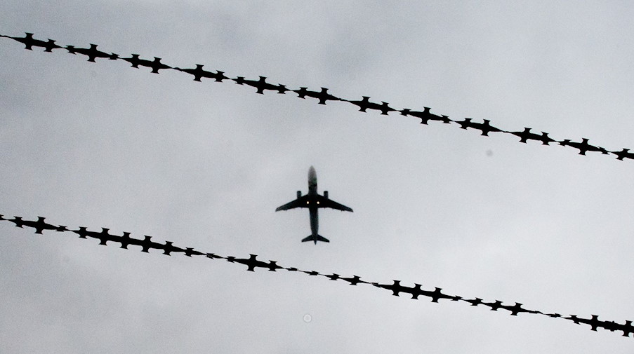 Ein Flugzeug ist hinter Stacheldraht zu sehen. / Foto: Julian Stratenschulte/dpa/Archivbild