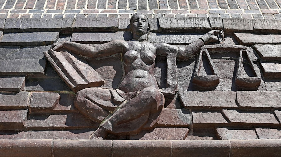 Blick auf die Justitia über dem Eingang eines Landgerichts. / Foto: Hendrik Schmidt/dpa-Zentralbild/dpa/Symbolbild