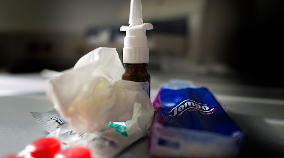 Anti-Erkältungsmittel wie Nasenspray, Halstabletten und Papiertaschentücher liegen auf einem Tisch. / Foto: Arno Burgi/dpa/Symbolbild