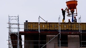 Arbeiter stehen auf einer Baustelle eines Wohngebäudes. / Foto: Soeren Stache/dpa-zentralbild/dpa/Symbolbild