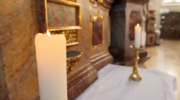 Kerzen brennen vor dem Sonntagsgottesdienst. / Foto: Silas Stein/dpa/Symbolbild
