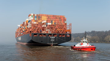 Ein Containerschiff wird von einem Schlepper über die Elbe bugsiert. / Foto: Markus Scholz/dpa/Symbolbild