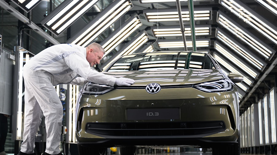 Rainer Jopp, Meister in der Fahrzeug Endabnahme in der Gläsernen Manufaktur, präsentiert ein E-Auto. / Foto: Robert Michael/dpa