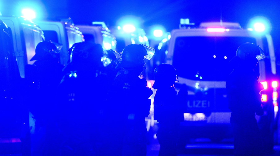 Polizisten stehen am Abend des 78. Jahrestages der Zerstörung Dresdens im Zweiten Weltkrieg zwischen Gegendemonstranten und einem Zug von Montagsdemonstranten in der Innenstadt. / Foto: Robert Michael/dpa