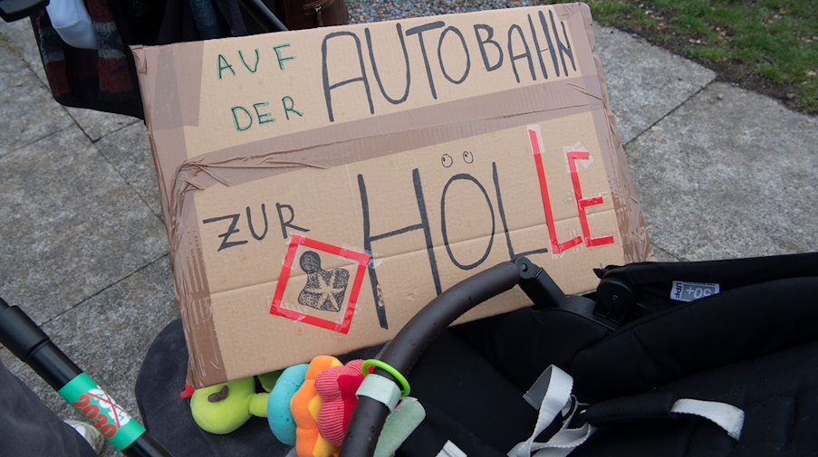 Auf einem Schild steht geschrieben " Auf der Autobahn zur Hölle". / Foto: Paul Zinken/dpa
