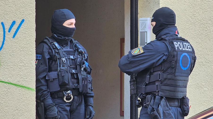 Polizisten stehen vor einem Haus im Leipziger Stadtteil Connewitz. / Foto: Tobias Junghannß/dpa
