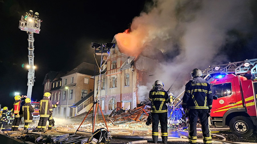 Die Feuerwehr löscht die Reste eines explodierten Hauses. / Foto: Mike Müller/dpa