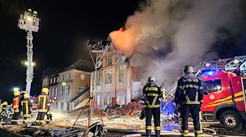 Die Feuerwehr löscht die Reste eines explodierten Hauses. / Foto: Mike Müller/dpa