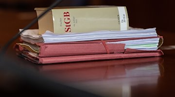 Das Strafgesetzbuch und Akten liegen in einem Gericht auf dem Tisch. / Foto: Swen Pförtner/dpa/Symbolbild