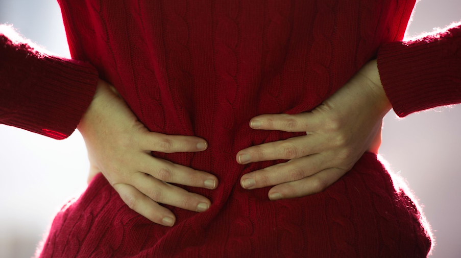 Eine Frau hält sich den Rücken. / Foto: picture alliance / Lino Mirgeler/dpa/Symbolbild