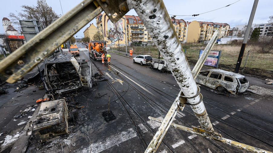 Ausgebrannte Autos stehen nach einem Brand an einer Gasleitung im Stadtteil Friedrichstadt am Straßenrand. / Foto: Robert Michael/dpa/Archivbild